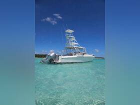 A striking view of a sleek boat anchored in crystal-clear waters, showcasing its elegant design against a vibrant blue sky — perfect for fishing or leisure outings.