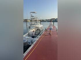 A young boy walks along the dock towards a fishing boat, where a crew member prepares for the day's adventure — a perfect scene for fishing enthusiasts.
