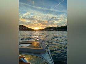 A stunning sunset view from the bow of a boat, showcasing the tranquil waters and scenic shoreline — perfect for evening cruises.