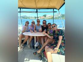 A group of friends enjoys cocktails together on a boat, celebrating their time on the water — perfect for a fun day out or special occasion.