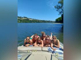 A fun group of friends enjoys a sunny day on the water, lounging on the boat with drinks in hand — perfect for a memorable celebration or getaway.