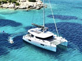 An aerial view of a catamaran anchored in crystal-clear waters, with a swimmer and a kayaker enjoying the vibrant marine environment — perfect for adventure seekers and water enthusiasts.