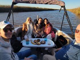 A cheerful group of friends enjoys snacks and drinks aboard a boat, creating memorable moments on the water.
