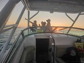 A group of friends enjoys a beautiful sunset on a boat, capturing the moment with smiles and laughter — perfect for memorable outings on the water.