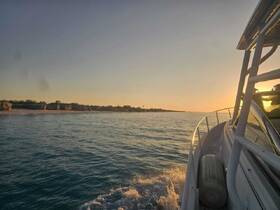 A serene sunset view from the side of a boat, showcasing the tranquil waters and distant coastline — perfect for evening cruises.