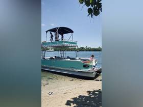 A family enjoys a sunny day on a pontoon boat, with children playing on the beach and adults relaxing on the deck — perfect for a fun-filled day on the water.