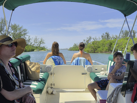 A family enjoys a relaxing day on a boat, taking in the scenic views of the waterway. Perfect for creating lasting memories on the water.