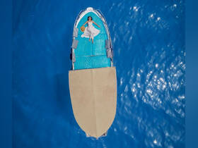 An aerial view of a woman relaxing on a boat in vibrant blue waters, showcasing a serene moment perfect for summer getaways or romantic escapes.
