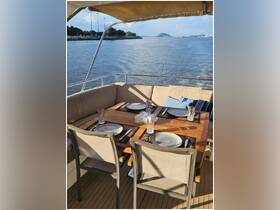 A beautifully set dining area on a boat, featuring a wooden table with plates and glasses, perfect for enjoying meals while cruising on the water.