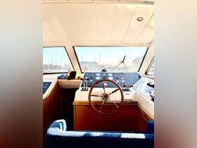 A well-lit view of the helm inside a yacht, showcasing the steering wheel and control console — perfect for navigating the open waters.