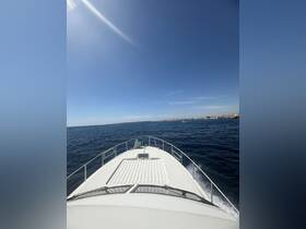 A stunning view from the front of a yacht cruising through clear waters, showcasing the vessel's sleek design against a bright blue sky.