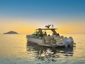 A group enjoys a serene sunset aboard a stylish boat, with a picturesque island in the background — perfect for memorable evening cruises.