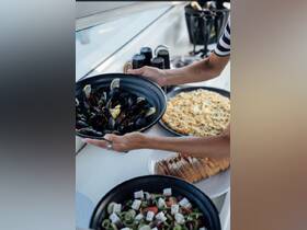 A beautifully arranged spread of seafood, salad, and bread on a boat, perfect for a luxurious dining experience at sea.