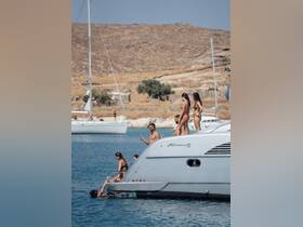 A lively group enjoys a sunny day on an Alfamarine boat, with some swimming in the water while others relax on the deck — perfect for summer adventures and fun on the water.
