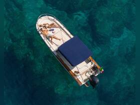 A couple relaxes on a boat under the sun, enjoying the clear turquoise waters — an ideal scene for summer getaways and romantic escapes.