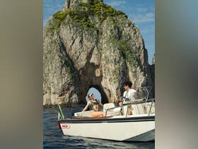 A couple enjoys a sunny day on a boat near a stunning rock arch, capturing the essence of adventure and romance on the water.