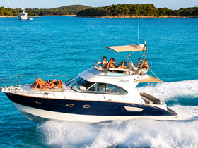 A lively group enjoys sunbathing on a yacht as it cruises through crystal-clear waters, perfect for summer adventures and social gatherings on the water.