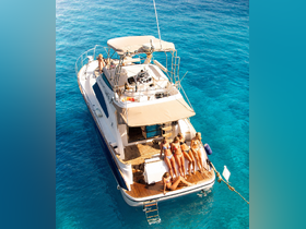 A group of friends enjoys a sunny day on a yacht, lounging and soaking up the sun over crystal-clear waters — perfect for summer getaways and boat parties.