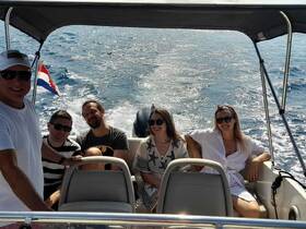 A cheerful group of friends enjoys a day out on the water, capturing the essence of fun and adventure aboard their boat.