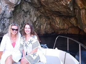 Two friends enjoy a scenic moment on a boat inside a cave, capturing the essence of adventure and exploration on the water.