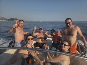 A lively group enjoys drinks and celebration aboard a boat, capturing the essence of fun on the water with friends.