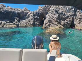 A scenic view of a group enjoying a swimming adventure in crystal-clear waters, surrounded by stunning rock formations — perfect for snorkeling and beach exploration.