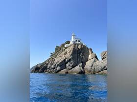 A stunning view of a lighthouse perched on a rocky cliff, surrounded by vibrant blue waters — a picturesque landmark perfect for coastal explorations.