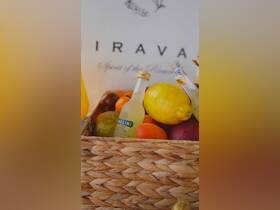 A beautifully arranged basket featuring fresh fruits and drinks, perfect for onboard refreshments during a luxurious boat trip.