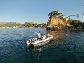 A group enjoys a scenic boat ride along the stunning coastline, with picturesque cliffs and clear waters creating the perfect backdrop for a memorable day on the water.