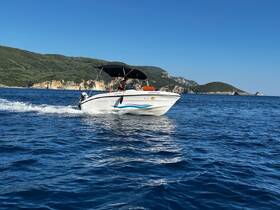 A speedboat cruises through vibrant blue waters, showcasing the stunning coastline in the background — perfect for adventurous outings on the sea.