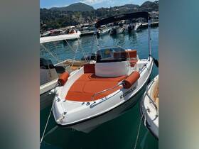A sleek speedboat docked in a picturesque marina, showcasing its vibrant orange seating and modern design, perfect for exploring coastal waters.