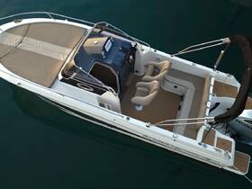 An aerial view of the interior of a sleek boat, showcasing comfortable seating and a well-equipped helm, perfect for a day on the water.