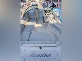 A spacious interior view of a boat featuring comfortable seating and a well-equipped helm, perfect for relaxing or navigating on the water.