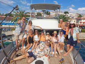 A lively group enjoys a sunny day aboard a yacht, showcasing fun and camaraderie — perfect for celebrations and group outings on the water.
