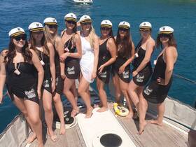 A lively group of bridesmaids celebrates aboard a boat, showcasing their 'Bride Squad' attire — perfect for bachelorette parties and memorable moments on the water.