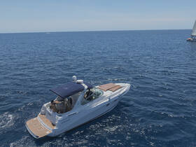 A stunning aerial view of a yacht cruising through deep blue waters, showcasing its sleek design and luxurious features.