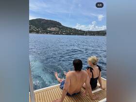 A couple enjoys a serene moment on the deck of a boat, taking in the beautiful coastal scenery — perfect for romantic getaways or relaxing days on the water.