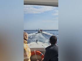 A scenic view from one boat capturing another boat in motion on the water, showcasing the joy of boating adventures.