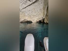 A serene view of a cave entrance reflected in crystal-clear waters, perfect for exploring hidden gems while boating.