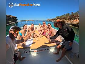A lively group enjoys drinks on a boat in Ibiza, celebrating under the sun — perfect for summer outings and memorable experiences on the water.