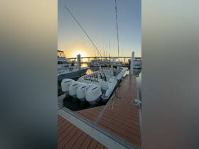 A sleek speedboat equipped with multiple Yamaha engines docked at a marina, set against a stunning sunset backdrop.