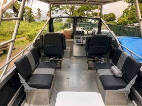 Interior view of a well-equipped boat cabin featuring comfortable seating and a modern helm, perfect for a day on the water.