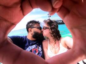 A couple shares a romantic kiss while enjoying a beautiful day on the water, capturing a perfect moment of love and adventure.