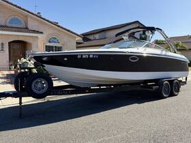 A sleek Cobalt boat is showcased on its trailer in front of a residential home, highlighting its stylish design and readiness for adventure on the water.