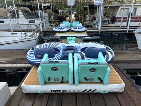 A collection of inflatable loungers and a cooler set up on a dock, perfect for a day of relaxation and fun on the water.