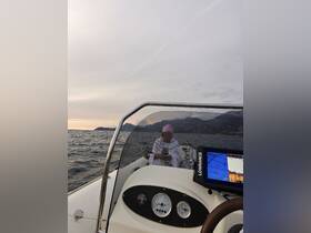 A serene moment on the water as a woman enjoys fishing from a boat during sunset, showcasing the tranquility of a fishing trip.