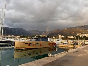 A stunning yacht docked at a marina with a rainbow in the background, showcasing the beauty of coastal scenery and luxury boating.