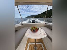 A beautifully arranged bowl of fresh fruit sits on a table inside a boat, perfect for enjoying snacks while cruising through scenic waters.