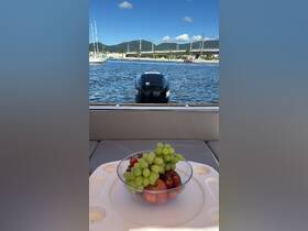 A bowl of fresh fruit including grapes, strawberries, and apples is displayed on a boat, perfect for enjoying snacks while cruising on the water.