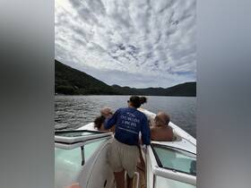 A group of people enjoying a boat ride with scenic hills in the background, perfect for a day of relaxation on the water.